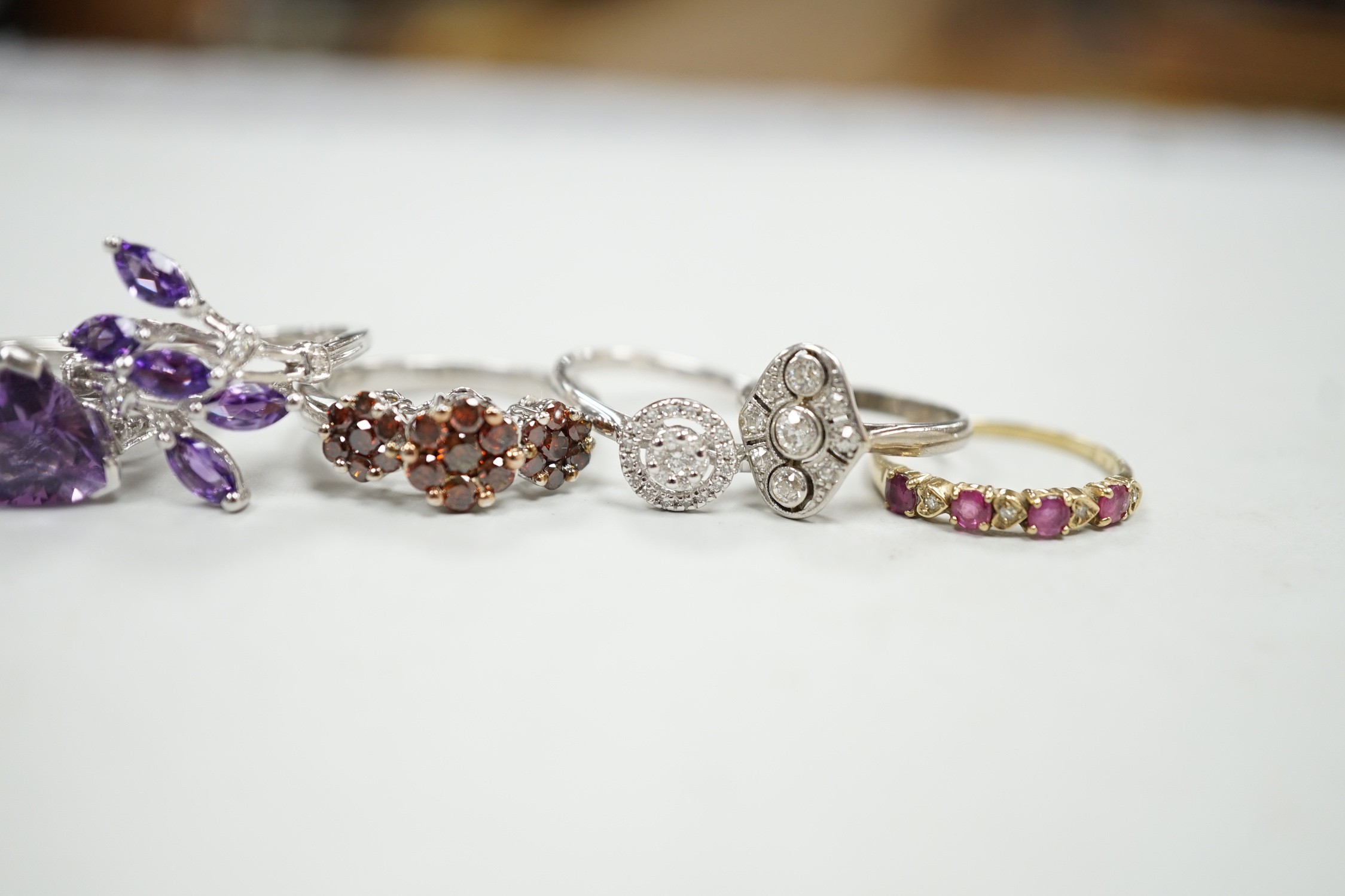 Five assorted modern 9ct gold and gem set dress rings, including diamond cluster ring, gross weight 14.2 grams, together with a 1920's style small white metal and millegrain set diamond cluster ring, size F/G, gross 2.6